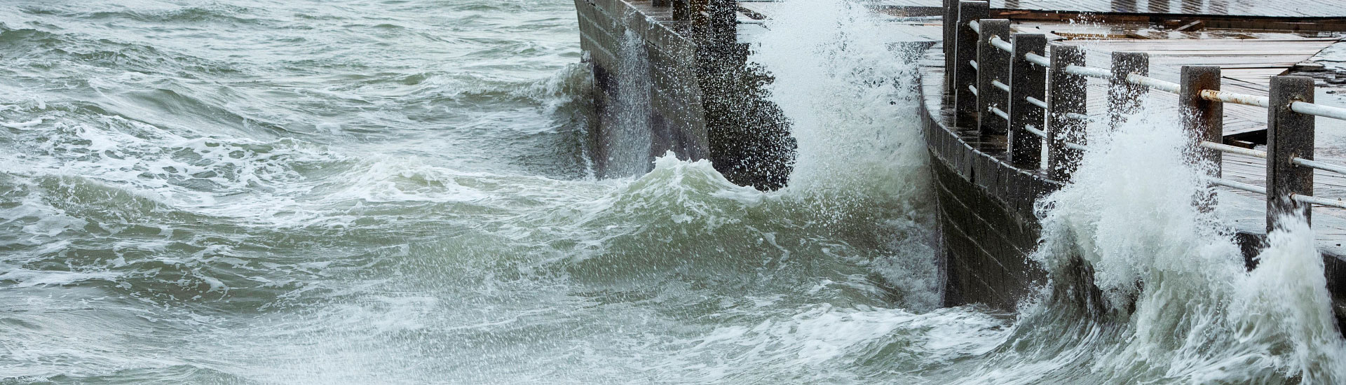 Stormy weather with waves on a brick shore.